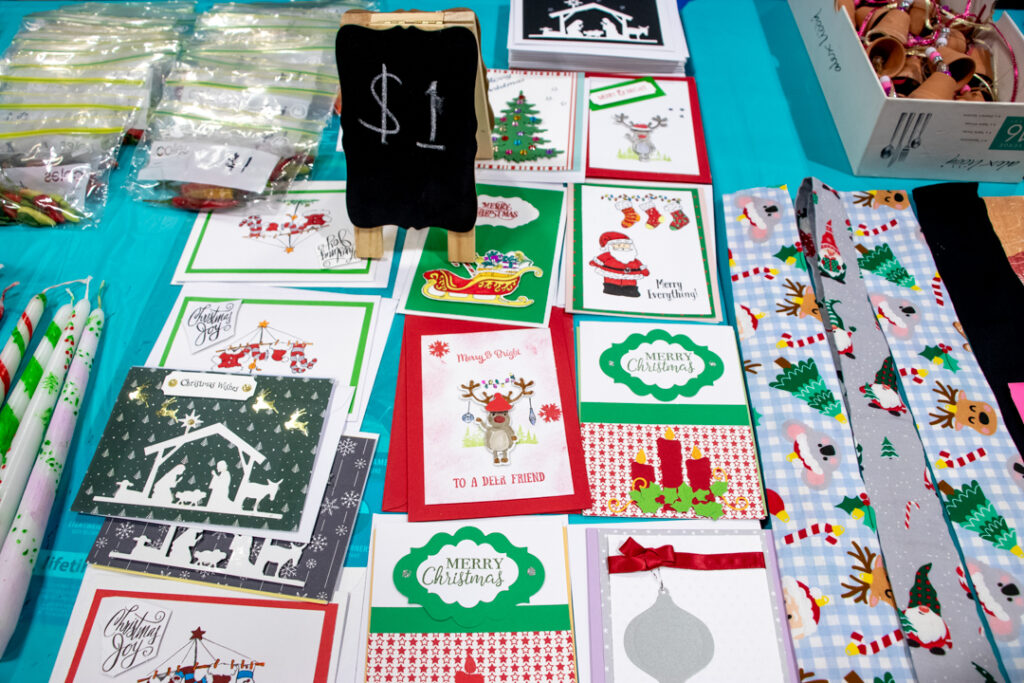 A collection of Christmas cards and decorations on a blue table cloth.