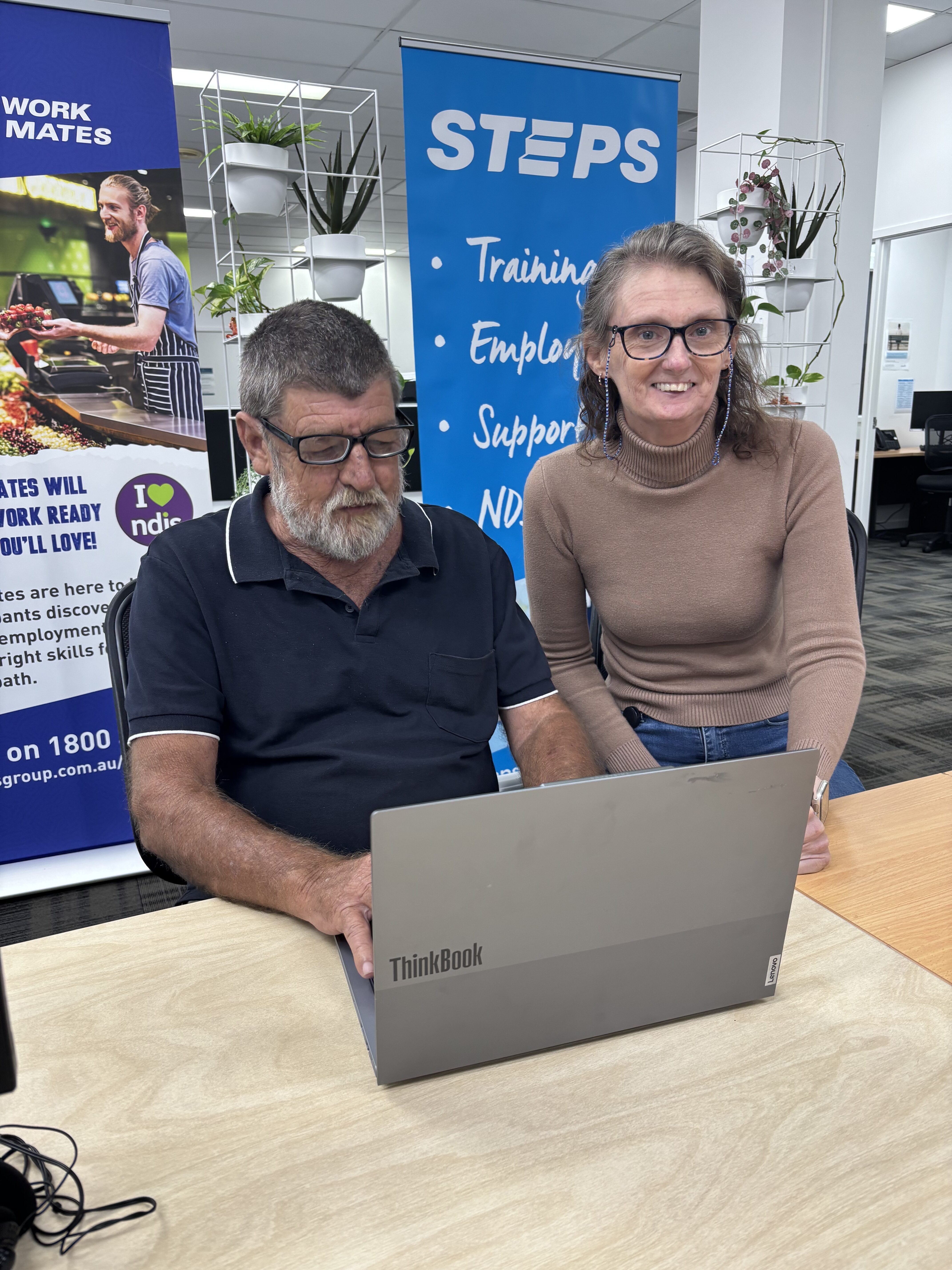 SEE participant on a laptop working with STEPS staff to build their digital literacy skills.