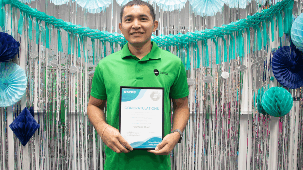 STEPS Skills for Education and Employment graduate Raymond holding his qualification certificate.
