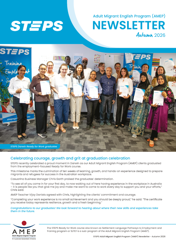 Group of AMEP students standing together at their graduation, holding certificates, alongside STEPS staff in front of program banners.