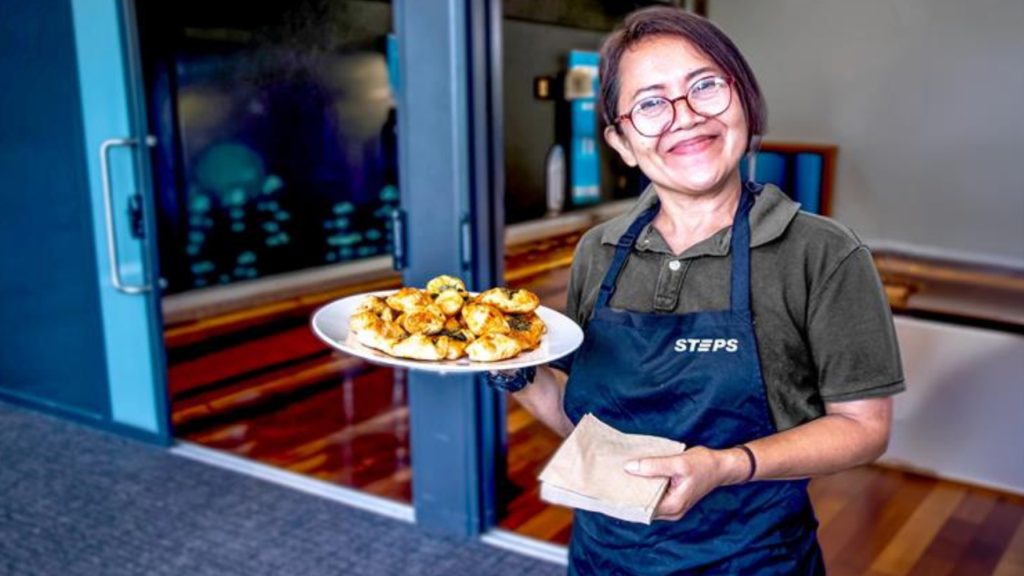 STEPS participant holding a plant of freshly prepared food.