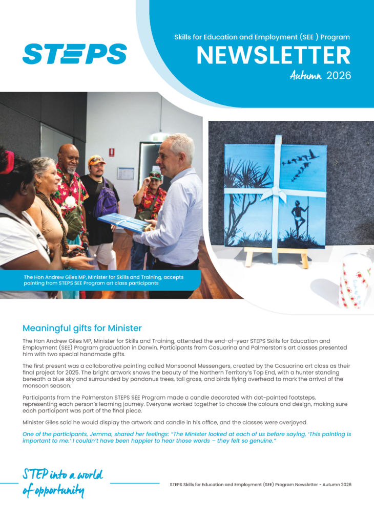 Minister Andrew Giles receives artwork created by SEE Program participants during a visit, with students and staff gathered around.