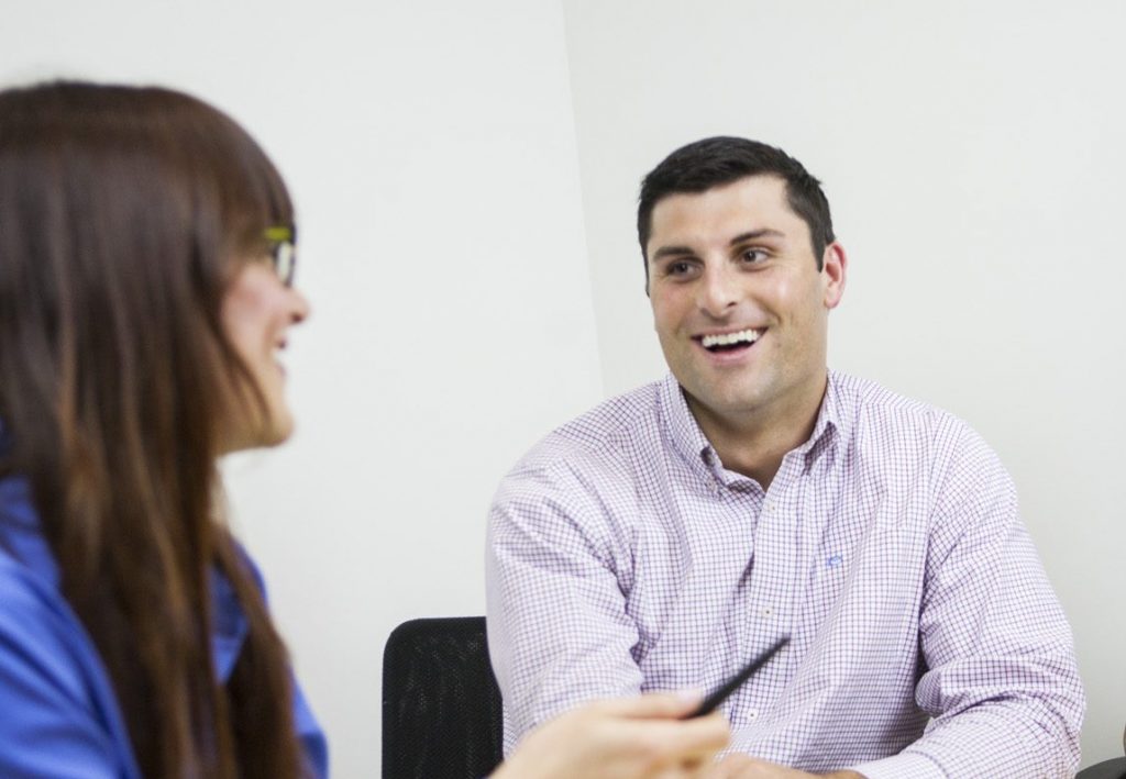 Man smiling with woman in office