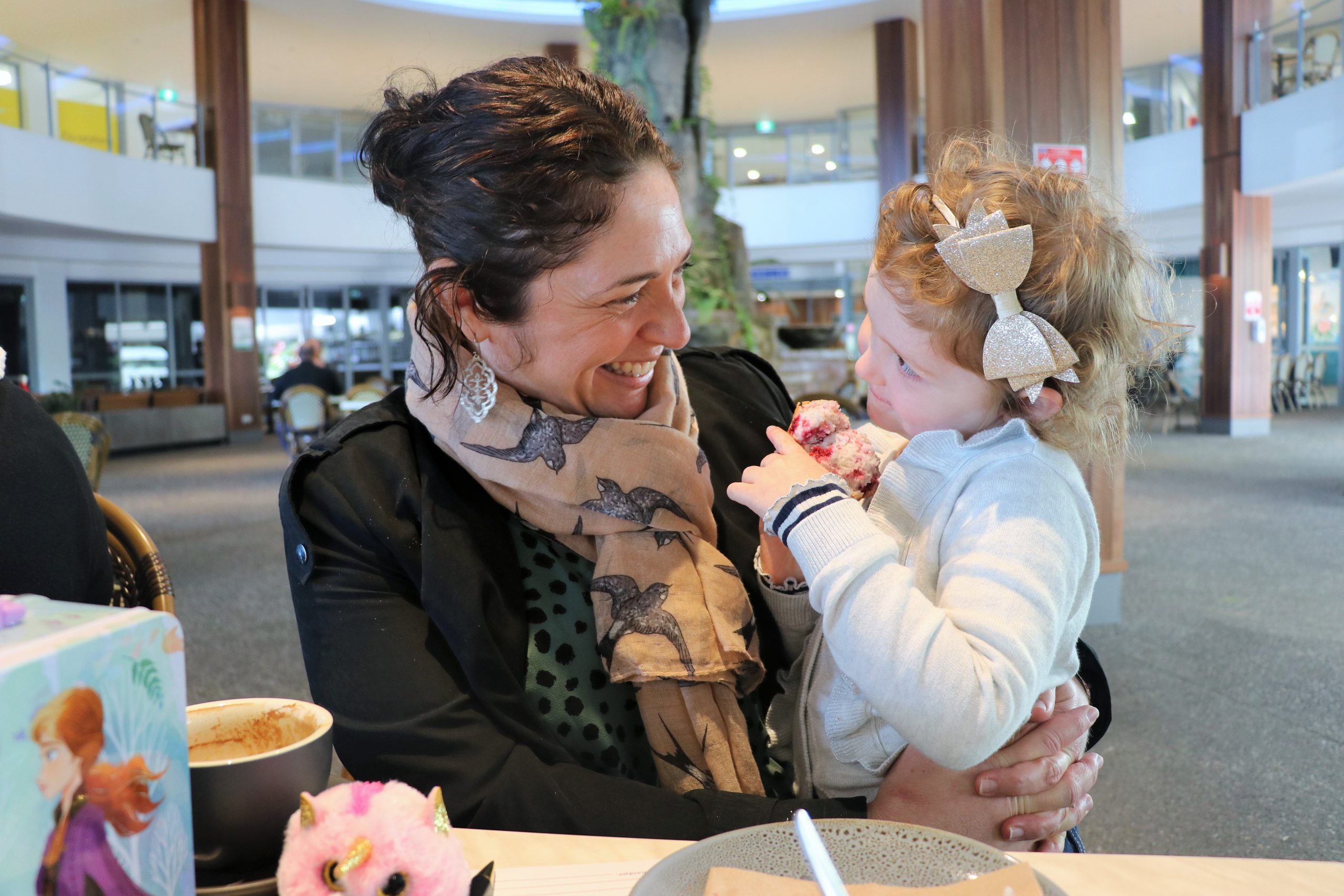 Mother holding young daughter and smiling