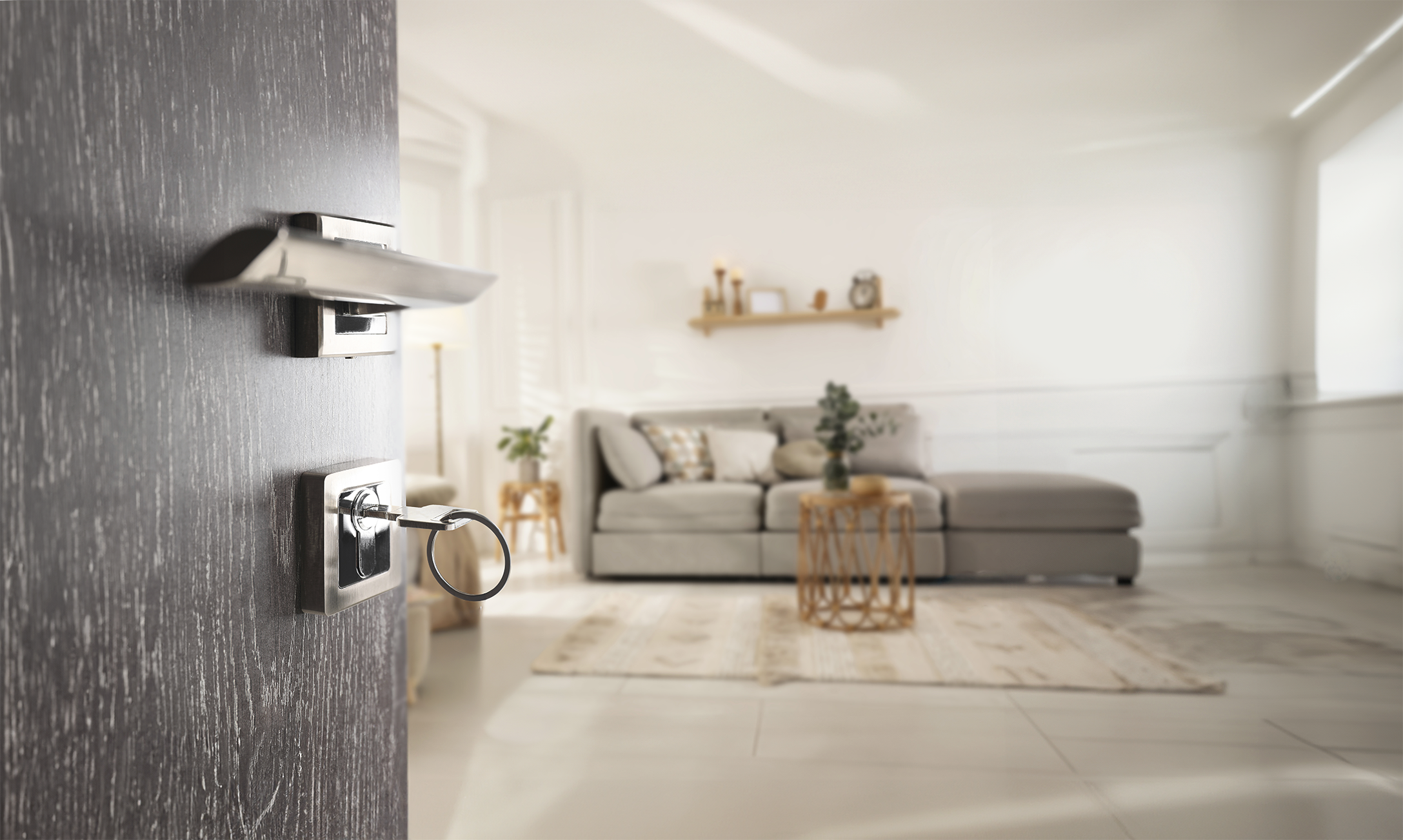 A close up of a brown door with a modern handle and lock. The door is open and leads into a bright modern room.